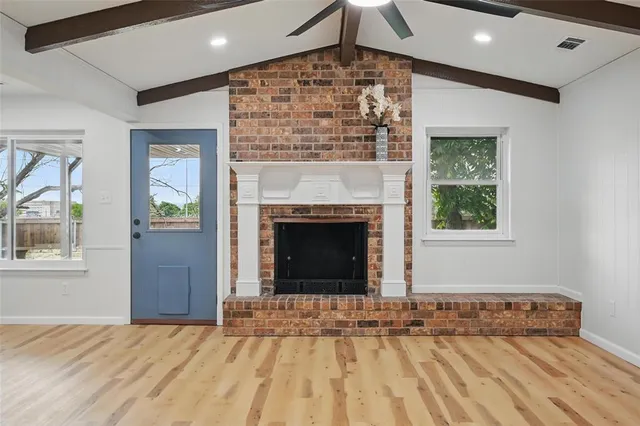 a view of an empty room with window and fire place