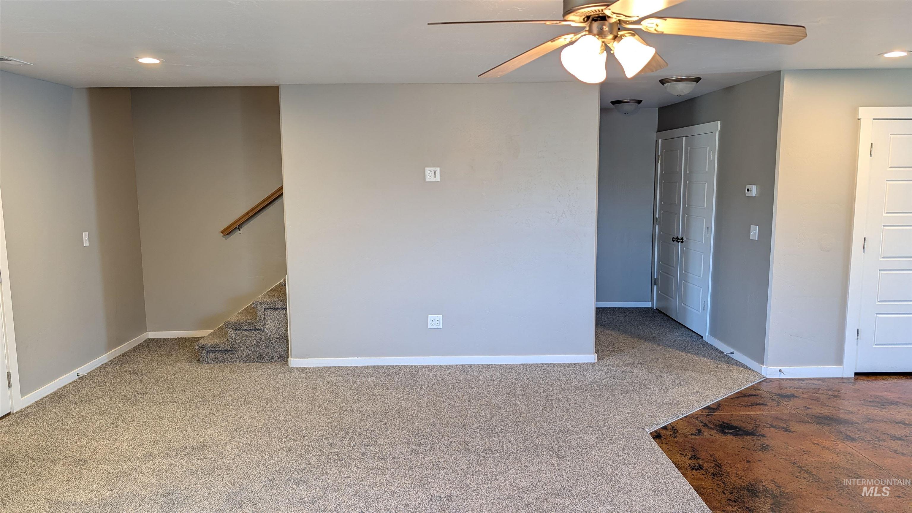 622 Lochsa Loop Heyburn, ID 83336 - Photo 4 of 17 Open-concept living space featuring neutral carpet and an adjacent area with stained concrete flooring