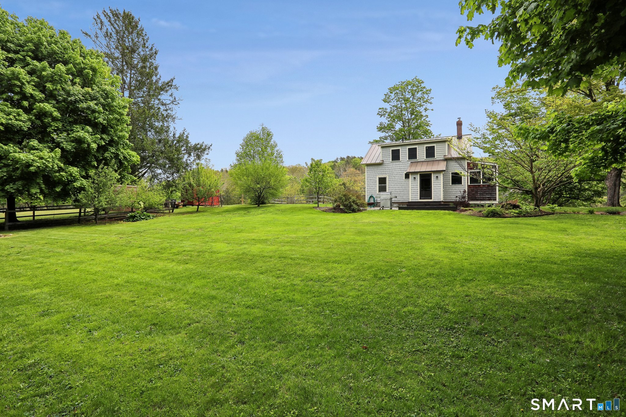 349 Litchfield Road New Milford, CT 06776 - Photo 2 of 27 a view of a white house with a big yard and large trees