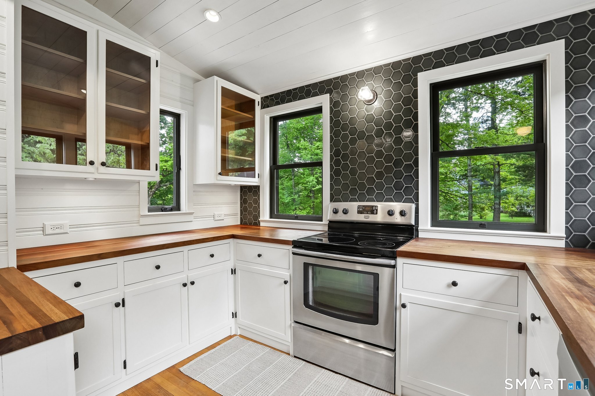 349 Litchfield Road New Milford, CT 06776 - Photo 7 of 27 a kitchen with granite countertop white cabinets and white appliances
