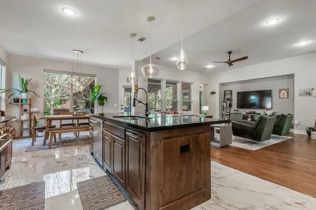 a kitchen with stainless steel appliances granite countertop a sink and a refrigerator