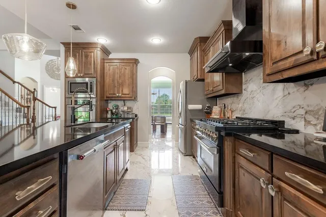 a kitchen with stainless steel appliances granite countertop a stove and a sink