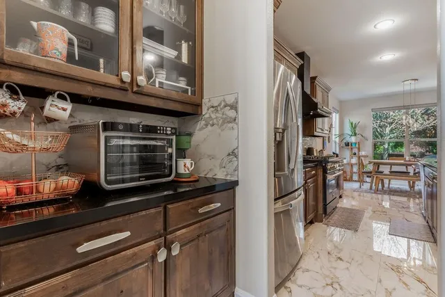 a kitchen with granite countertop a table chairs sink and cabinets