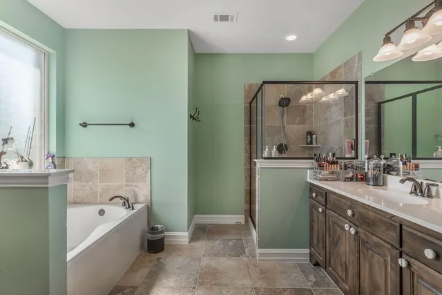 a spacious bathroom with a tub sink and mirror