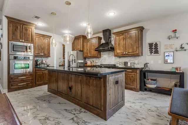 a kitchen with stainless steel appliances granite countertop a stove sink and cabinets