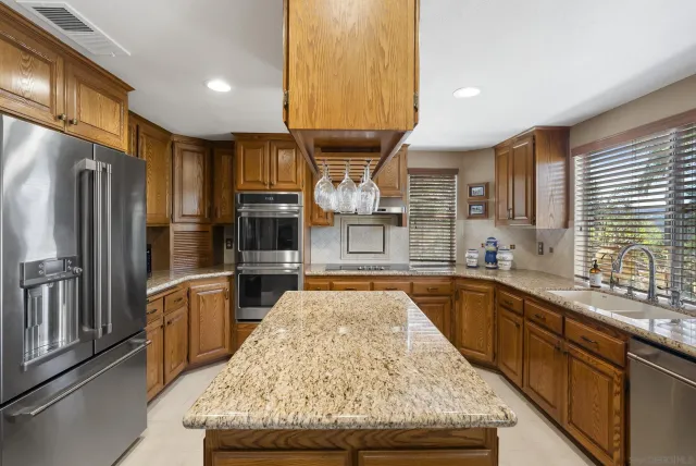 a kitchen with stainless steel appliances granite countertop a sink stove and refrigerator