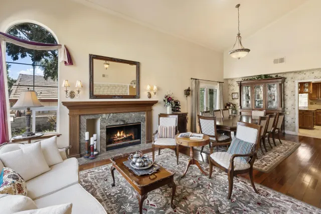 a living room with furniture a fireplace and a table