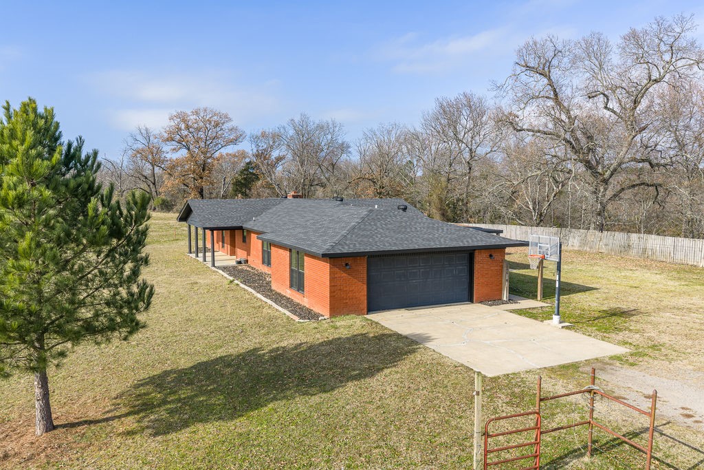 3022 Dow Jones Road Alma, AR 72921 - Photo 21 of 34 View of home's exterior with concrete driveway, roof with shingles, brick siding, and a garage