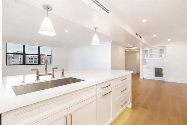 a spacious bathroom with a granite countertop sink a mirror and shower