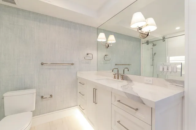 a bathroom with a sink a toilet and a mirror