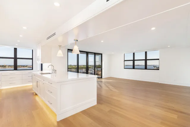 a large white room with wooden floor and windows