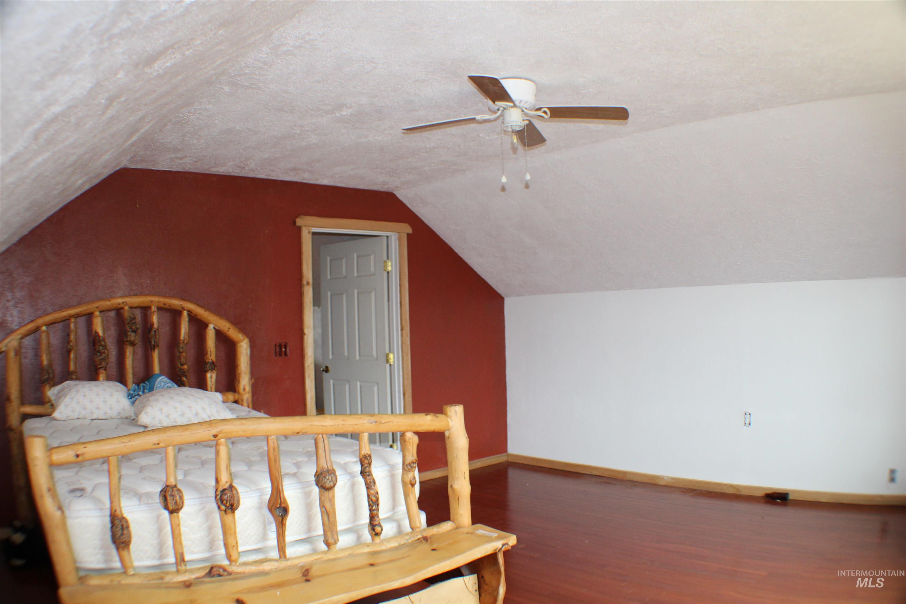 200 East Prairie Road Mountain Home, ID 83647 - Photo 36 of 38 Bedroom with a textured ceiling, wood finished floors, lofted ceiling, and a ceiling fan