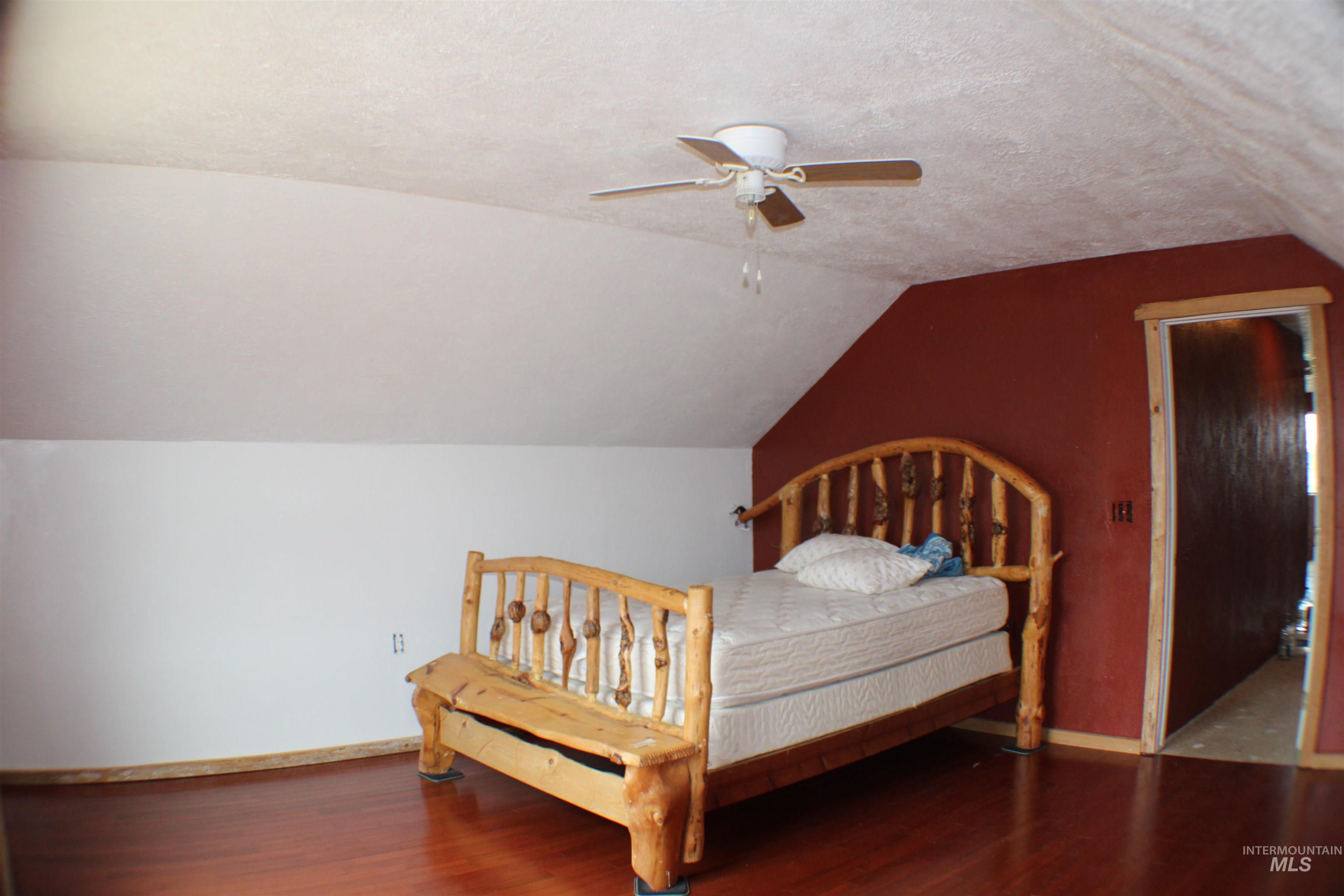 200 East Prairie Road Mountain Home, ID 83647 - Photo 37 of 38 Bedroom featuring a textured ceiling, vaulted ceiling, wood finished floors, and a ceiling fan