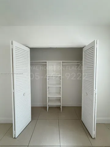 an empty room with walk in closet and empty shelves