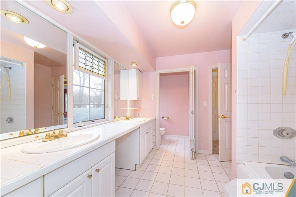 26 Moquis Trail Oak Ridge, NJ 07438 - Photo 20 of 23 a large bathroom with a double vanity sink a mirror and a bathtub
