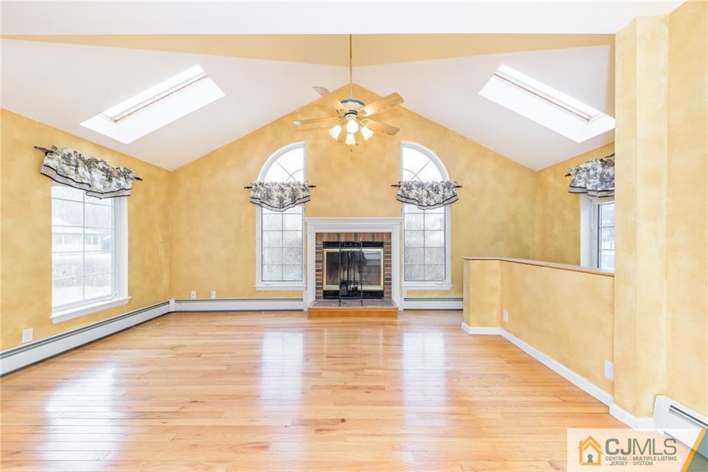 26 Moquis Trail Oak Ridge, NJ 07438 - Photo 7 of 23 a view of a livingroom with wooden floor a fireplace and window
