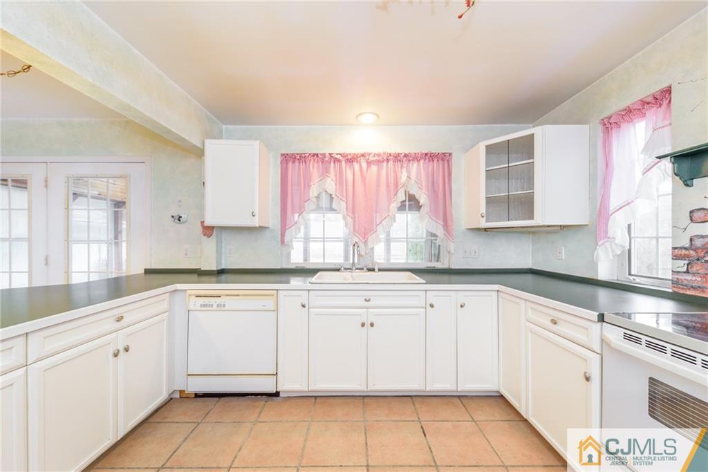 26 Moquis Trail Oak Ridge, NJ 07438 - Photo 10 of 23 a kitchen with white cabinets granite counter tops and a stove