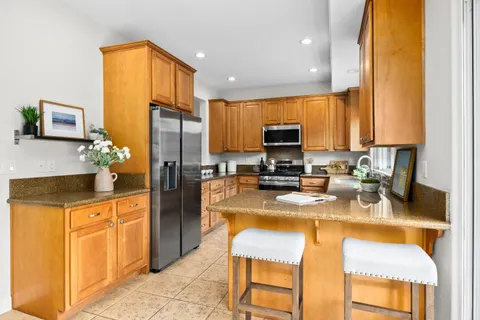 a kitchen with stainless steel appliances granite countertop a refrigerator stove microwave and sink