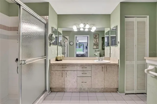 a bathroom with a granite countertop sink a mirror and a shower