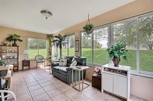 a living room with patio furniture and a floor to ceiling window