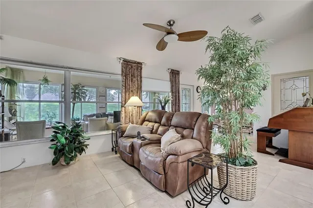 a living room with furniture plant and a large window