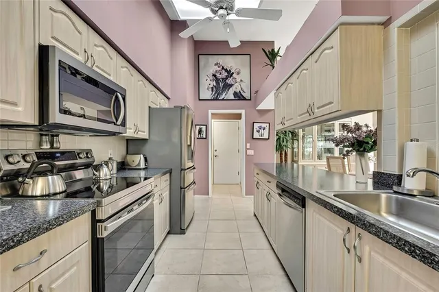 a kitchen with stainless steel appliances granite countertop a sink stove and cabinets