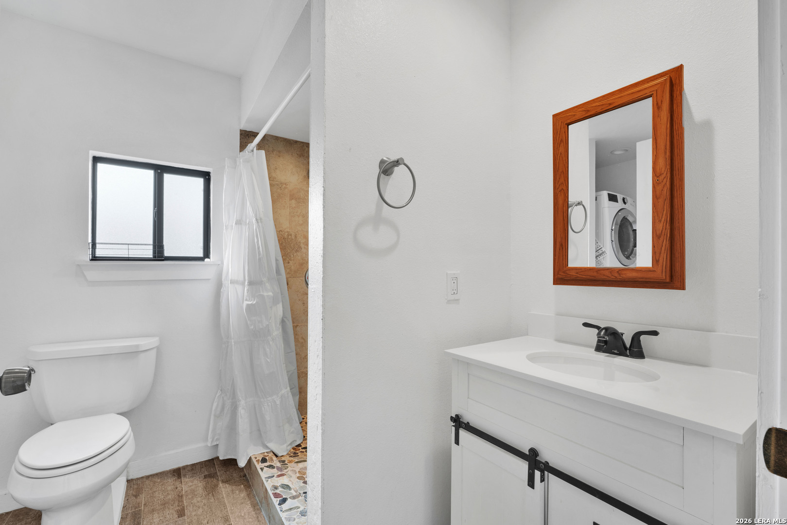18460 Interstate 37 Elmendorf, TX 78112 - Photo 23 of 28 a bathroom with a toilet a sink and mirror