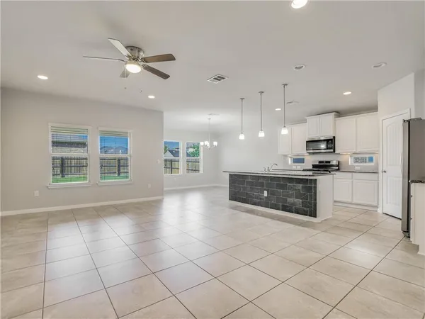 a large kitchen with a stove a sink and a refrigerator