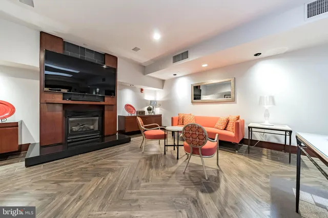 a living room with furniture a rug and a bookshelf