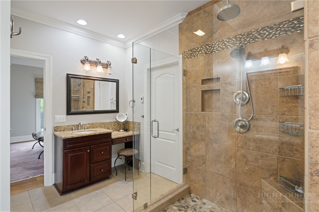 147 Riverside Park Court, Unit G2 Jefferson, NC 28640 - Photo 11 of 44 a bathroom with a granite countertop sink a mirror and a shower