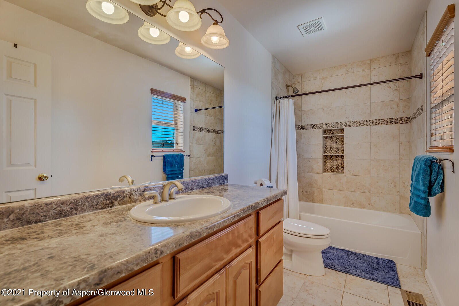 925 East 18th Street Rifle, CO 81650 - Photo 19 of 24 a bathroom with a granite countertop sink a toilet a mirror a vanity and shower