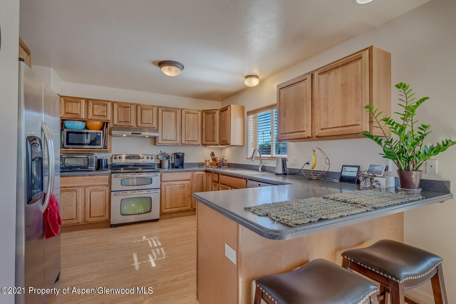 925 East 18th Street Rifle, CO 81650 - Photo 6 of 24 a kitchen with kitchen island granite countertop a stove a sink and a refrigerator