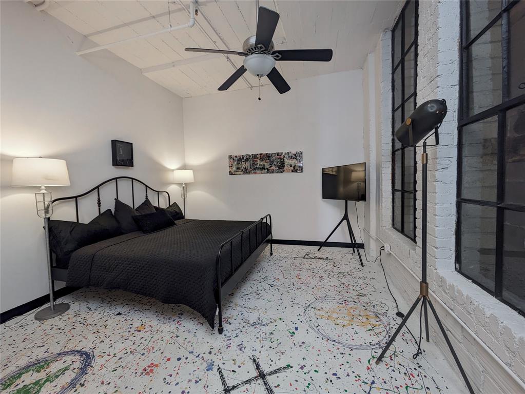 1122 Jackson Street, Unit 301 Dallas, TX 75202 - Photo 16 of 23 a bedroom with a bed and a lamp on table