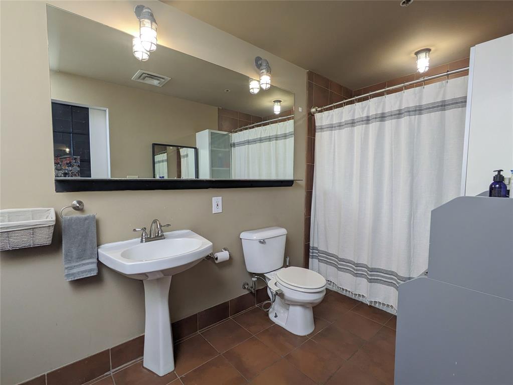1122 Jackson Street, Unit 301 Dallas, TX 75202 - Photo 18 of 23 a bathroom with a toilet sink and mirror