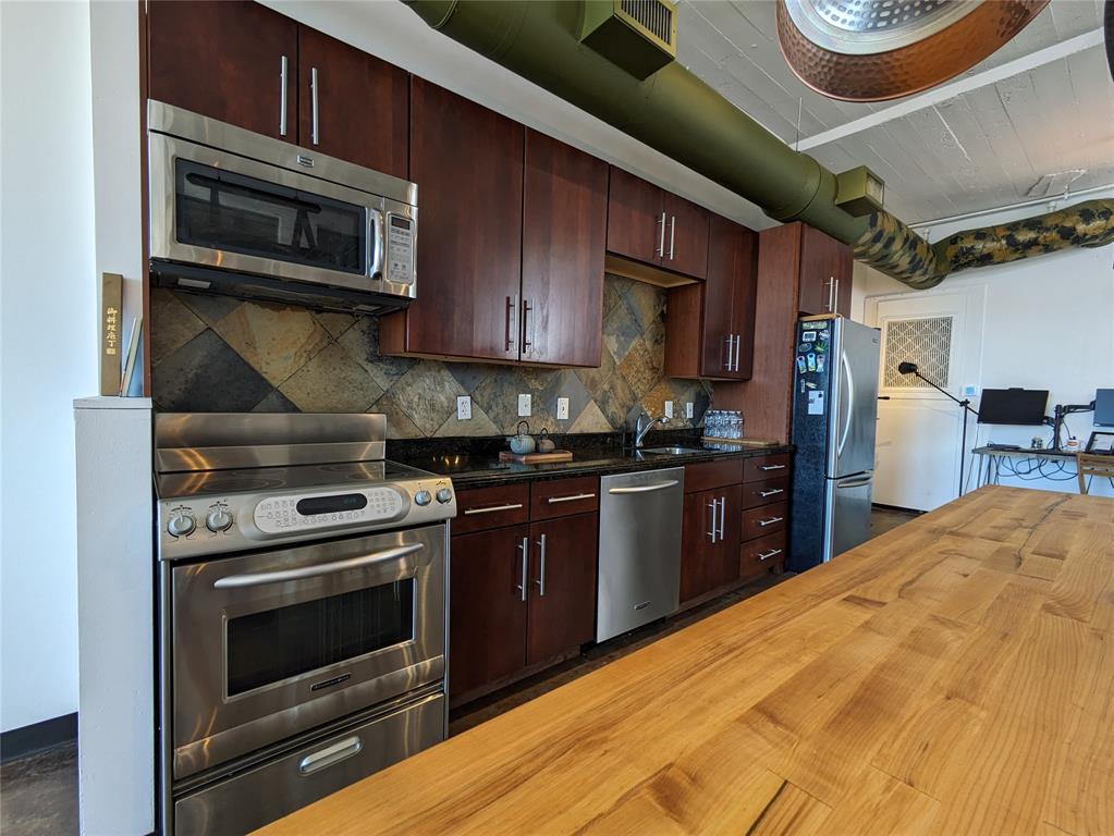 1122 Jackson Street, Unit 301 Dallas, TX 75202 - Photo 8 of 23 a kitchen with stainless steel appliances granite countertop a stove microwave and cabinets