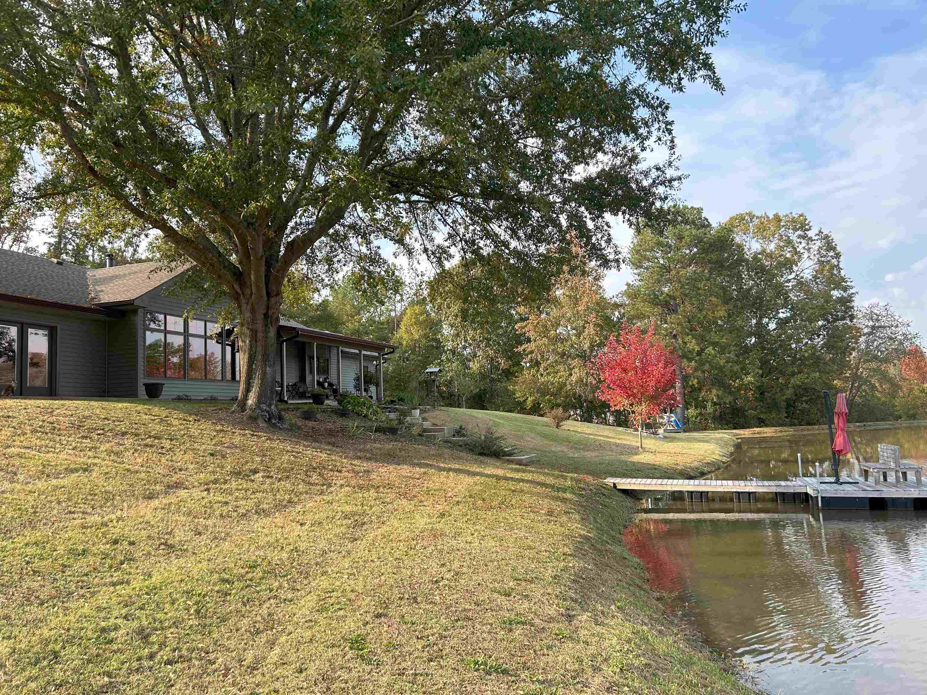 View of yard featuring a sunroom and a water view