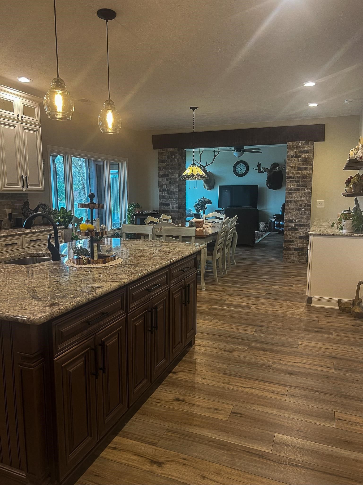 1231 Murray School Road Selmer, TN 38375 - Photo 10 of 39 Kitchen with light stone countertops, sink, dark hardwood / wood-style floors, decorative light fixtures, and dark brown cabinets