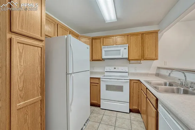 a kitchen with a refrigerator sink and cabinets