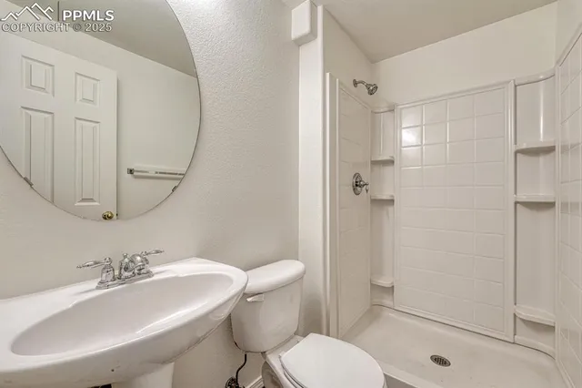 a bathroom with a sink toilet a mirror and shower