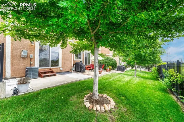 a house view with a garden space and patio