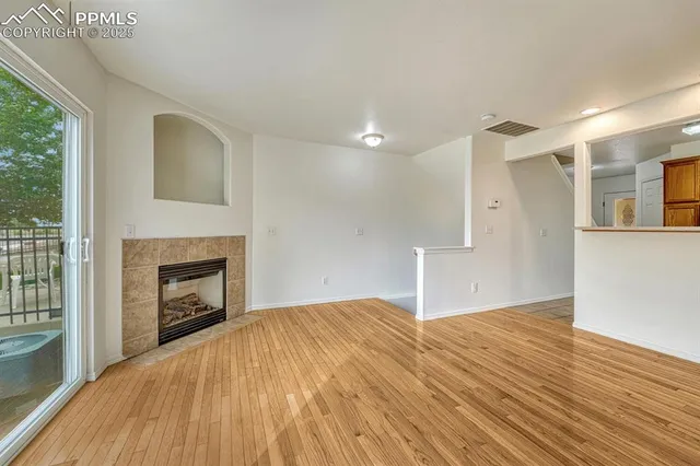 an empty room with a window and a ceiling fan