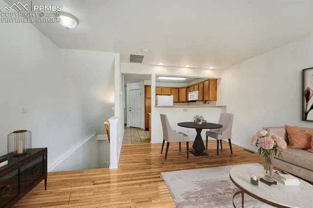 a living room with furniture a wooden floor and next to a window