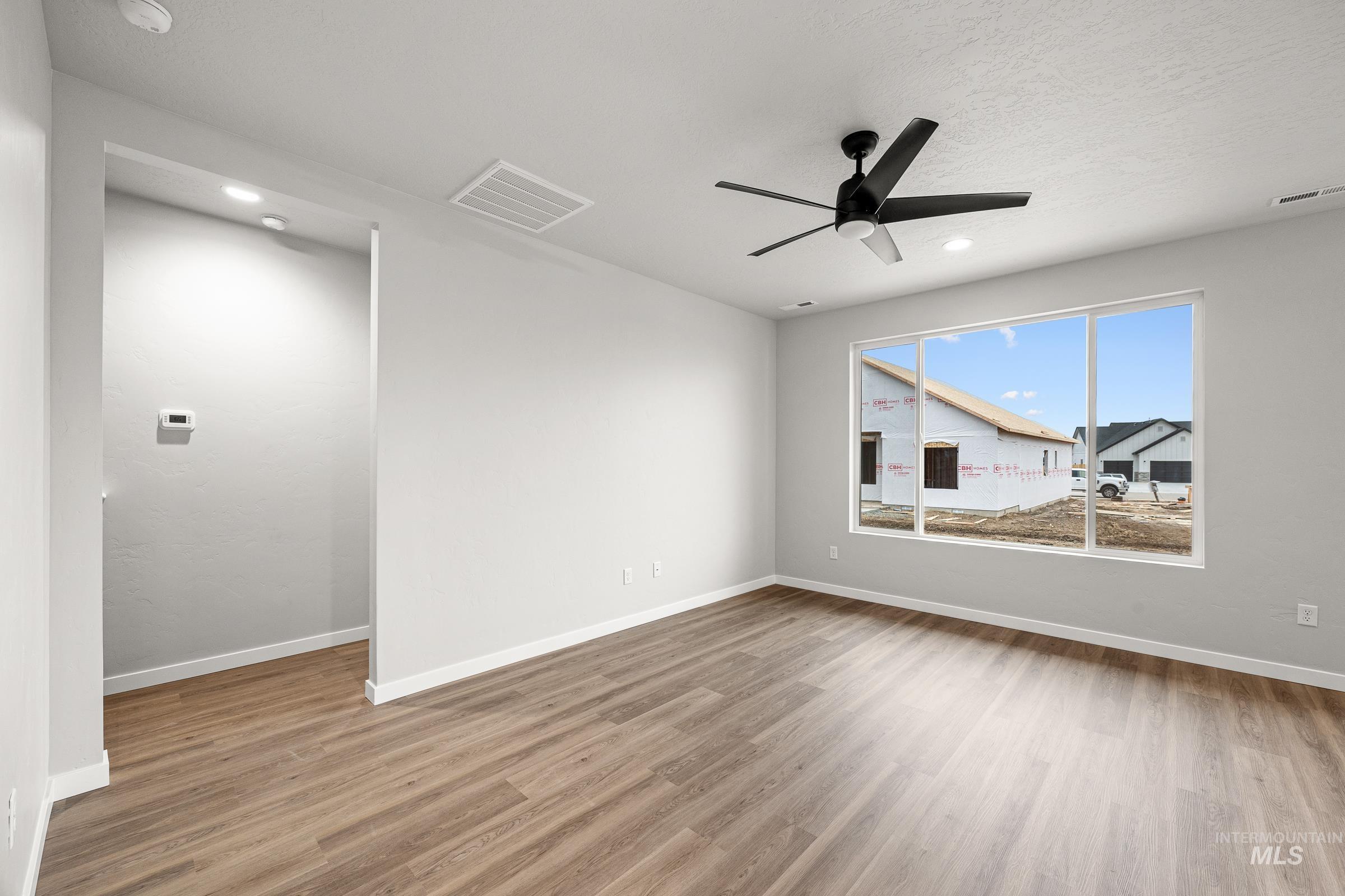 13656 Redway Court Caldwell, ID 83607 - Photo 9 of 21 Spacious interior room featuring wood-finish flooring, light gray walls, and white trim