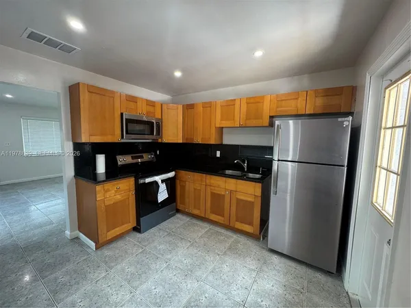a kitchen with stainless steel appliances granite countertop a refrigerator a stove a sink and a refrigerator