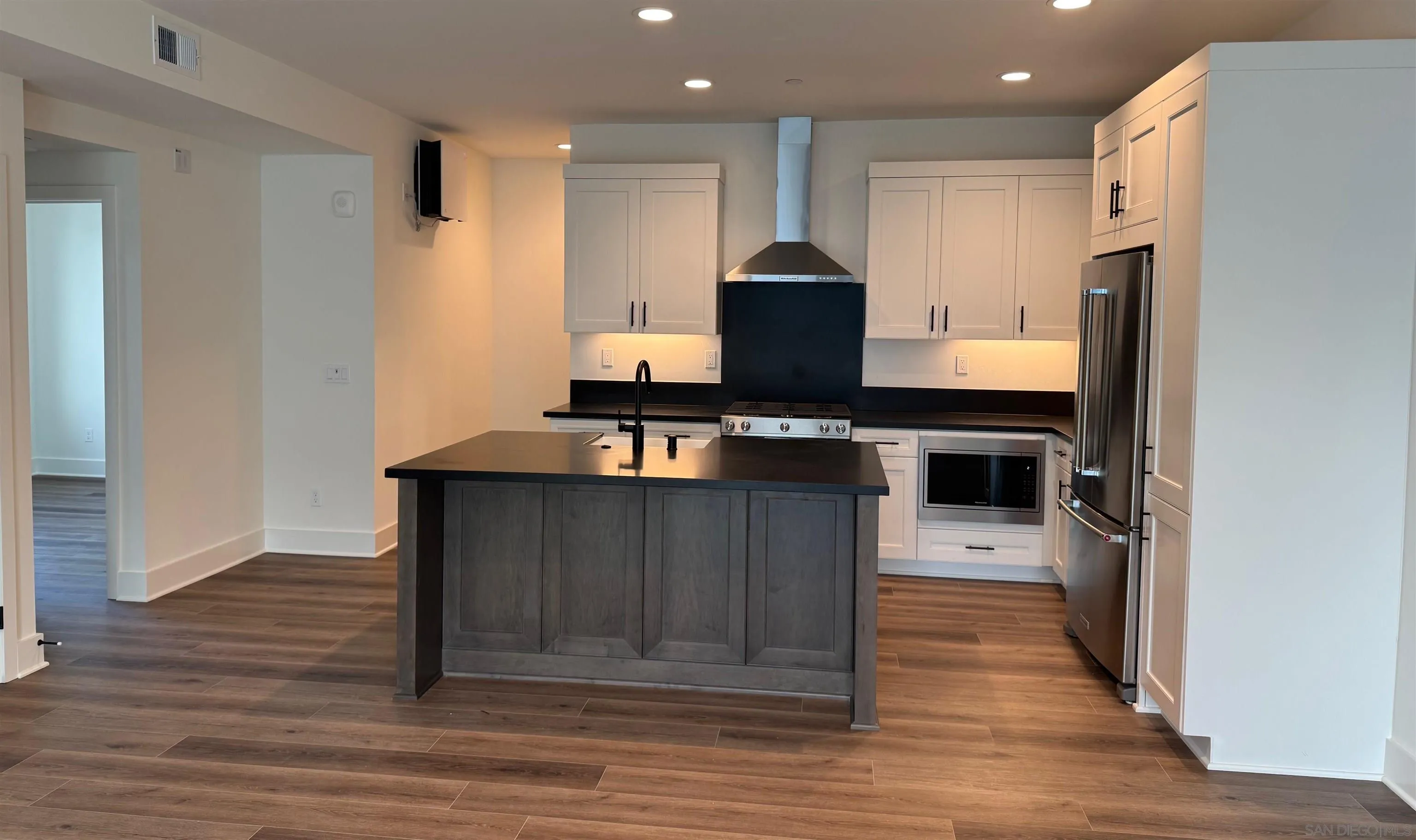 1107 Catania Court, Unit 205 Encinitas, CA 92024 - Photo 3 of 13 a kitchen with stainless steel appliances a stove refrigerator and cabinets