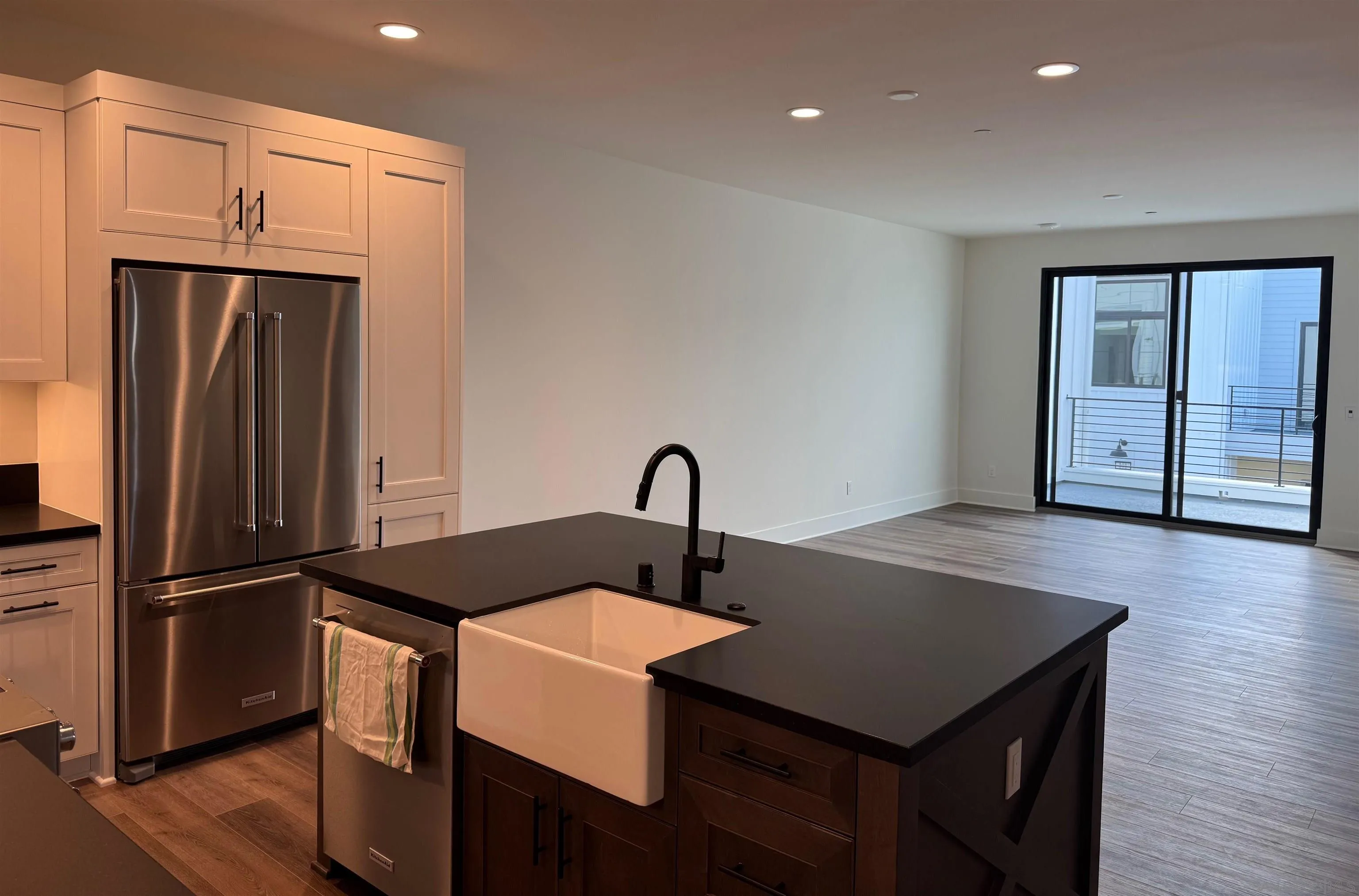 1107 Catania Court, Unit 205 Encinitas, CA 92024 - Photo 4 of 13 a kitchen with a sink a refrigerator and wooden floor
