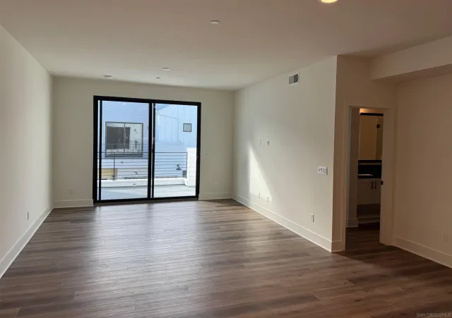 an empty room with wooden floor and closet