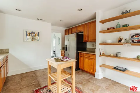 a kitchen with stainless steel appliances kitchen island granite countertop a refrigerator and a stove top oven