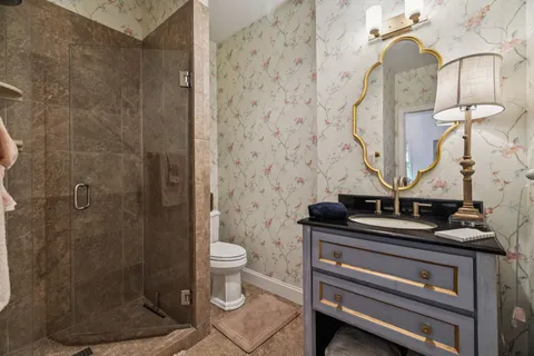 a bathroom with a granite countertop sink a toilet and a mirror