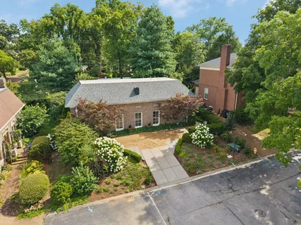 a view of a house with a yard and tennis court